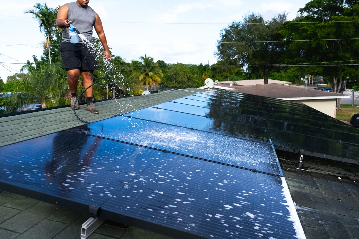 Solaris technician soft-scrubbing solar panels in Miami